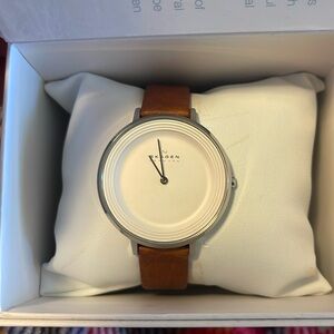 Skagen watch.  White face with silver accents and leather ban